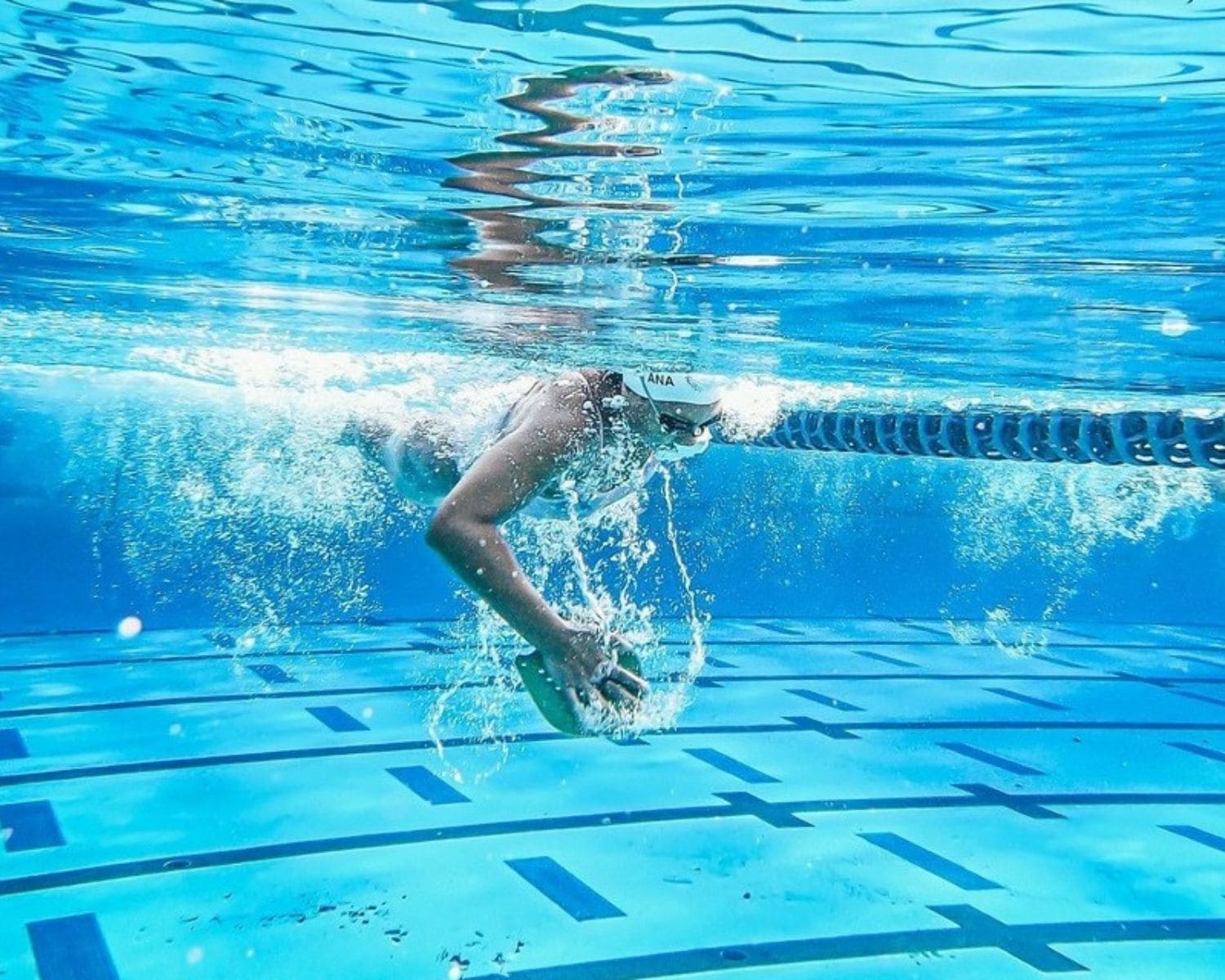 Nadadora submarina entrenando en piscina representando la fluidez y técnica asociadas a Arena